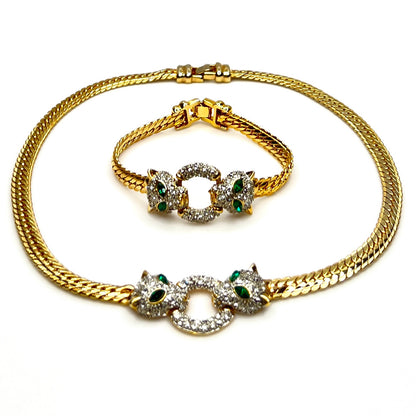 Close-up Vintage necklace and bracelet set with rhinestone panther heads and gold herringbone chains