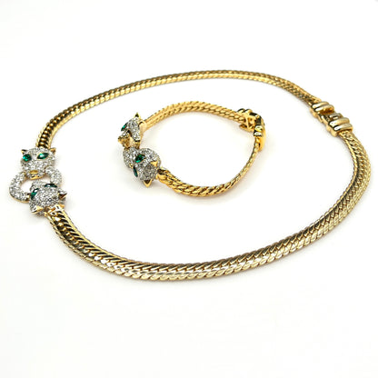 Side view of Vintage necklace and bracelet set with rhinestone panther heads and gold herringbone chains
