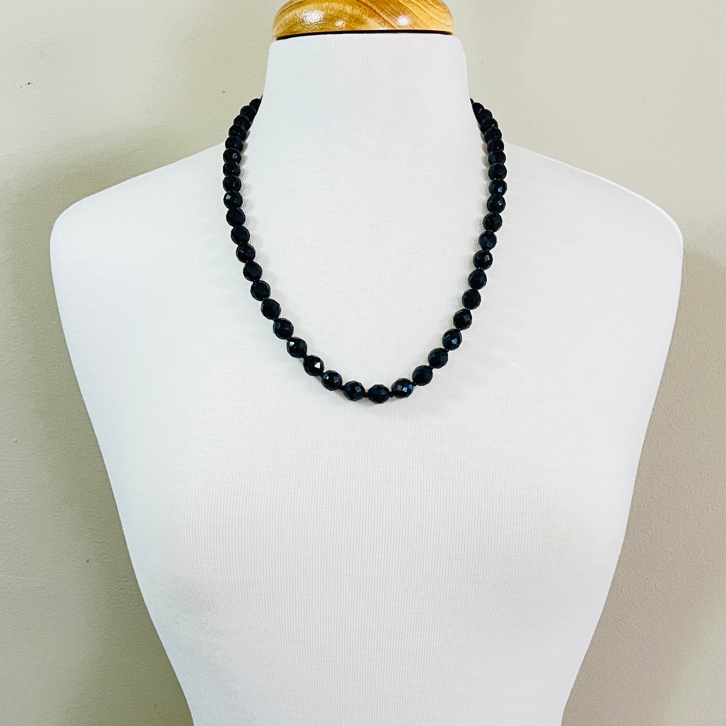 Vintage jet black faceted glass bead necklace worn on mannequin