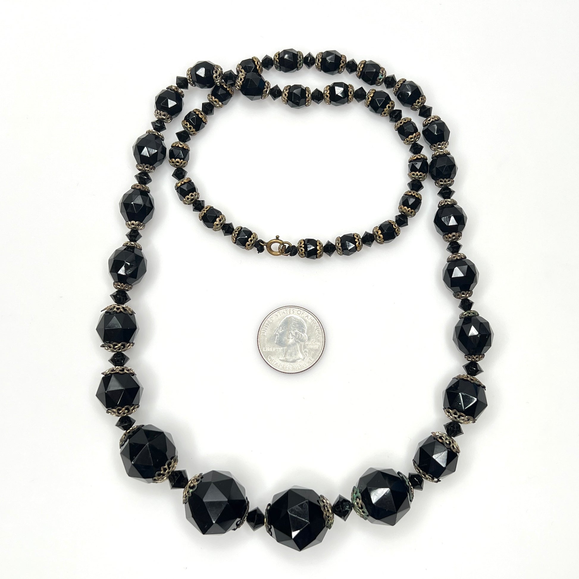 Vintage black glass necklace with graduated beads and brass-tone accents