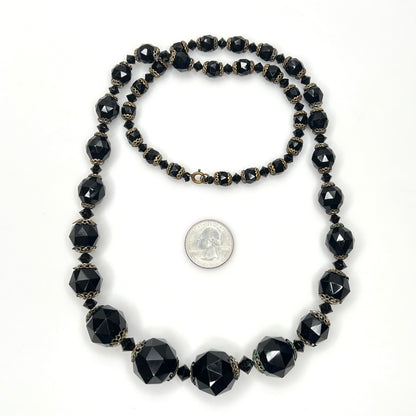 Vintage black glass necklace with graduated beads and brass-tone accents