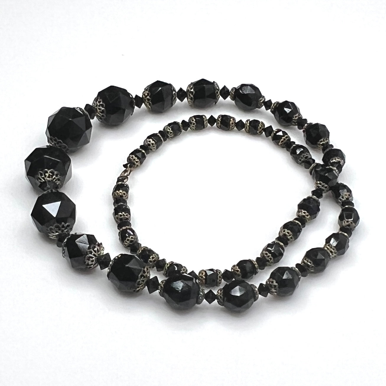 Vintage black glass necklace with graduated beads and brass-tone accents