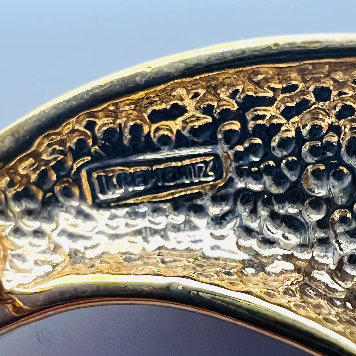 Close-up of Krementz maker's mark on reverse of vintage celestial brooch.