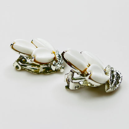 Side view of vintage Lisner white lucite clip-on earrings in silver-tone setting