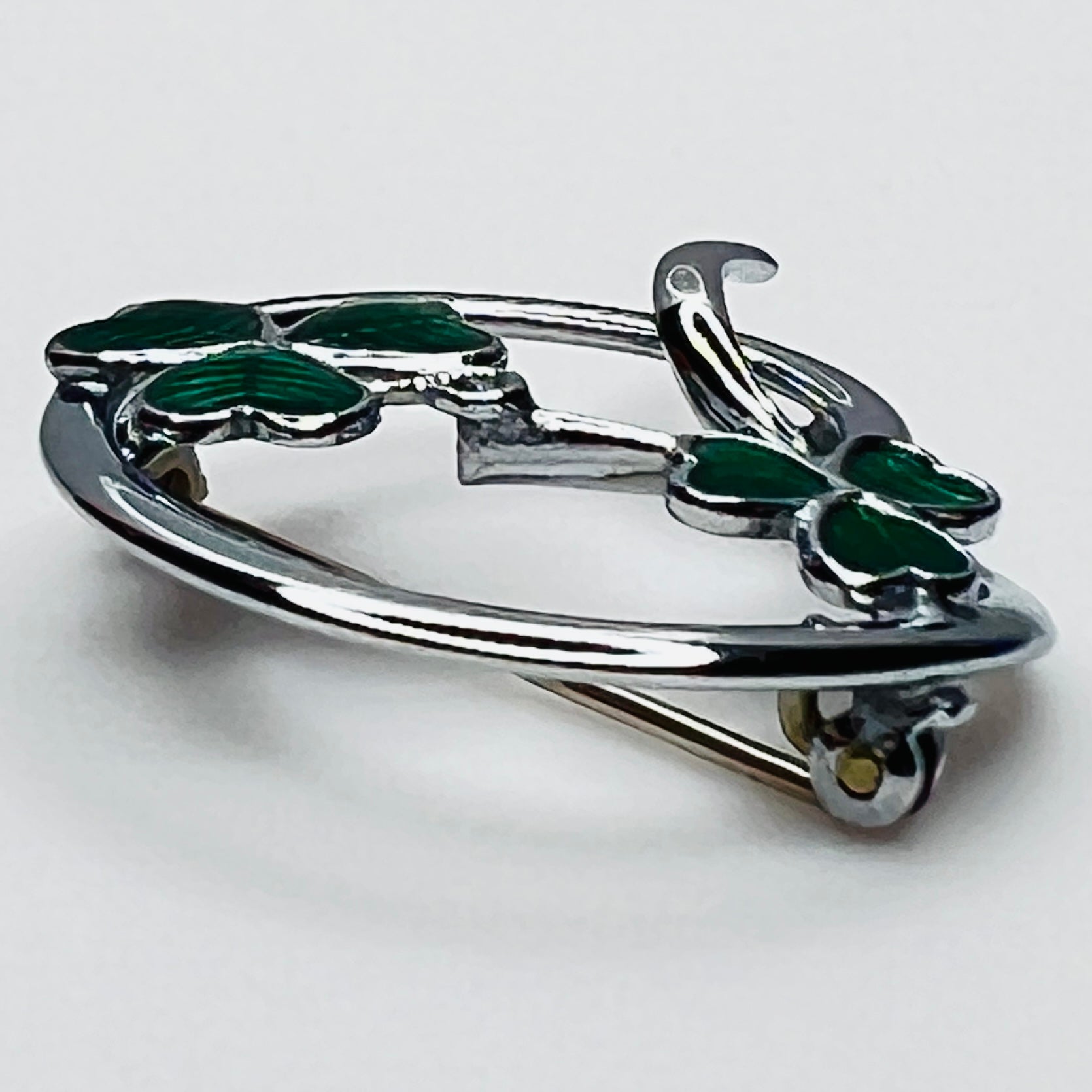 Side profile of vintage Mizpah green enamel shamrock brooch showing dimensional design.