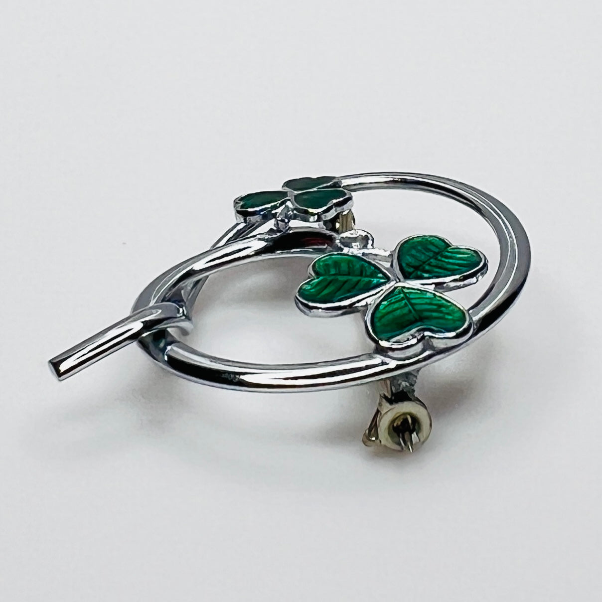 Side profile of vintage Mizpah green enamel shamrock brooch showing dimensional design.