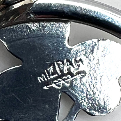Close-up of Mizpah hallmark on vintage green enamel shamrock brooch.