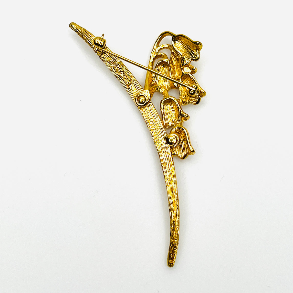 Reverse of 1960s Monet lily of the valley brooch showing gold-tone construction and rollover clasp