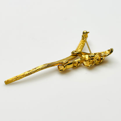 Side view of vintage gold-tone Monet flower brooch showing dimensional bell blossoms and textured stem