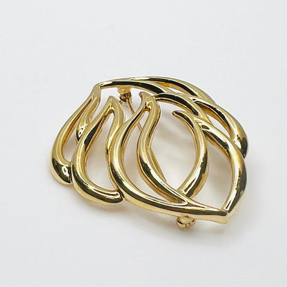 Side profile of vintage Monet statement brooch showing dimensional overlapping gold-tone metal curves