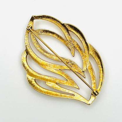 Reverse of vintage Monet openwork brooch showing textured gold-tone metal and pin clasp construction