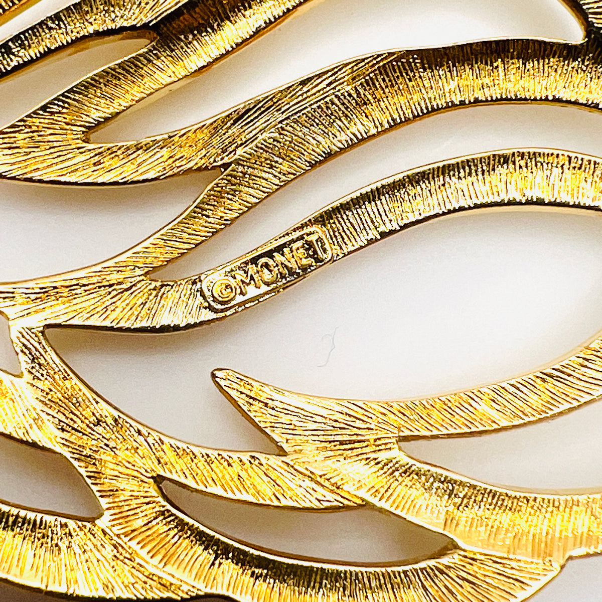 Close-up of Monet maker's signature and copyright mark on reverse of vintage gold-tone brooch