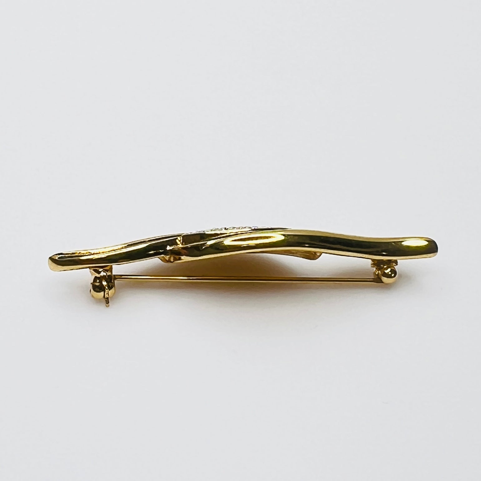 Side profile of vintage Monet rhinestone and enamel bar brooch