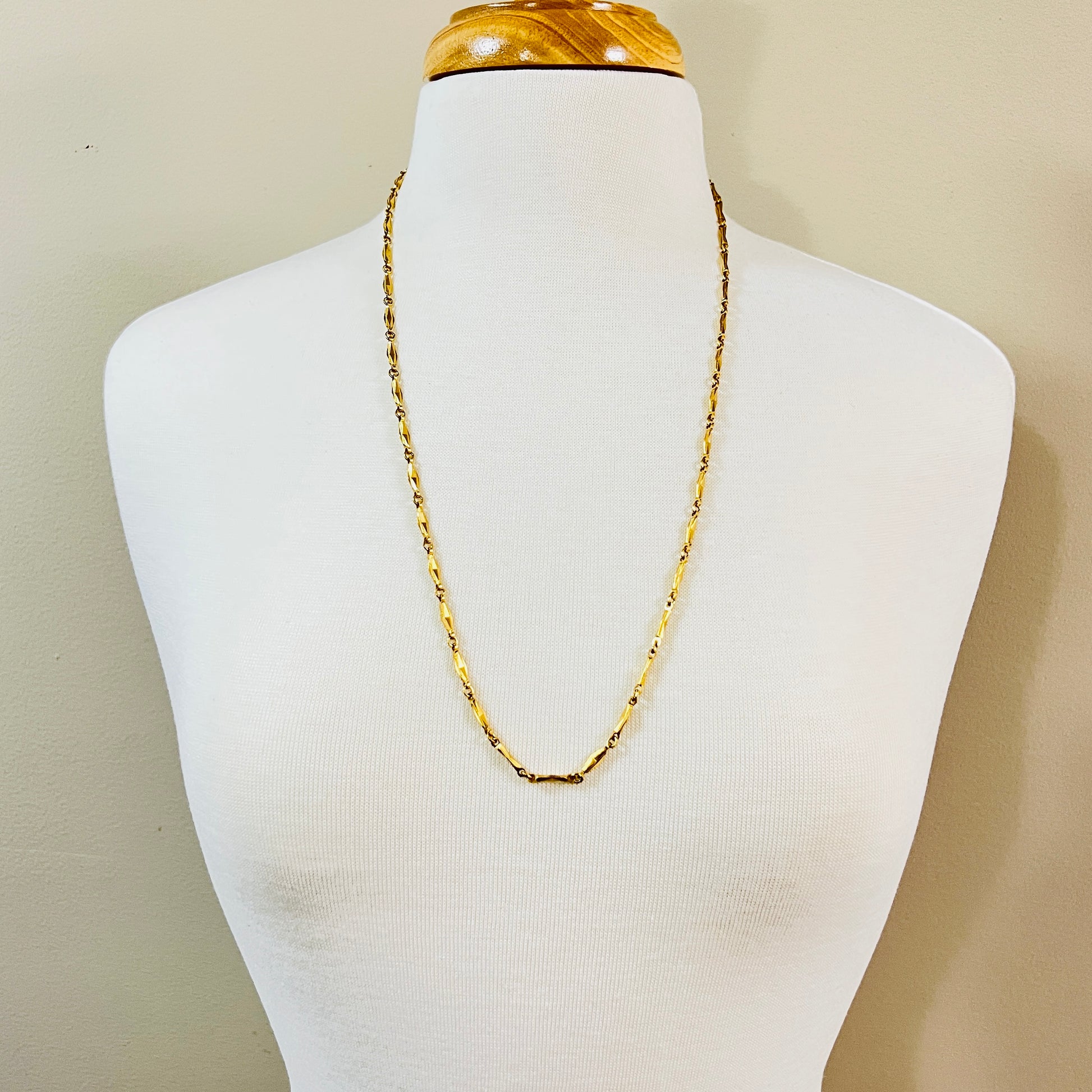 Long gold Monet chain necklace worn on mannequin