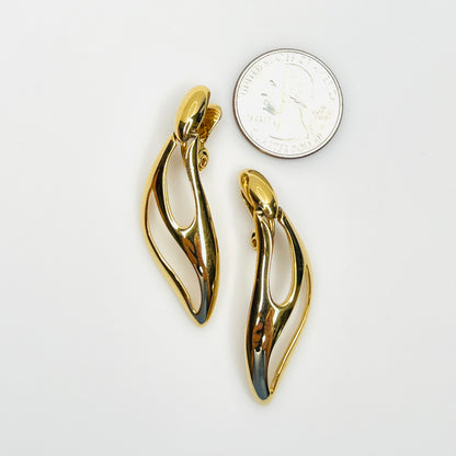 Signed Monet gold-tone modernist earrings shown beside quarter for scale