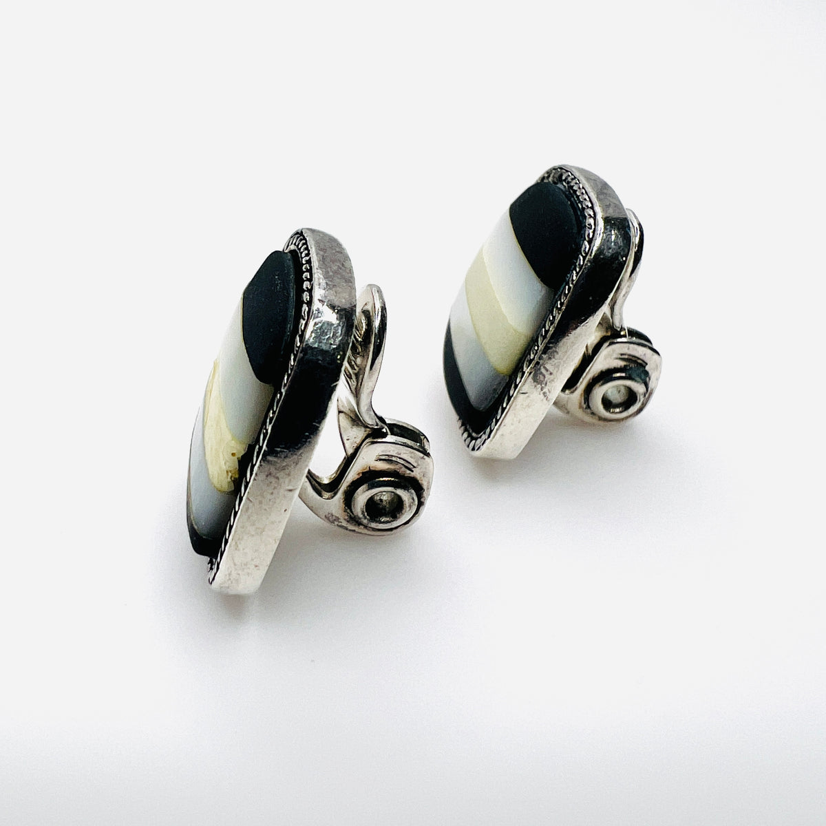 Side view of vintage Monet inlay clip-on earrings showing silver-tone clips