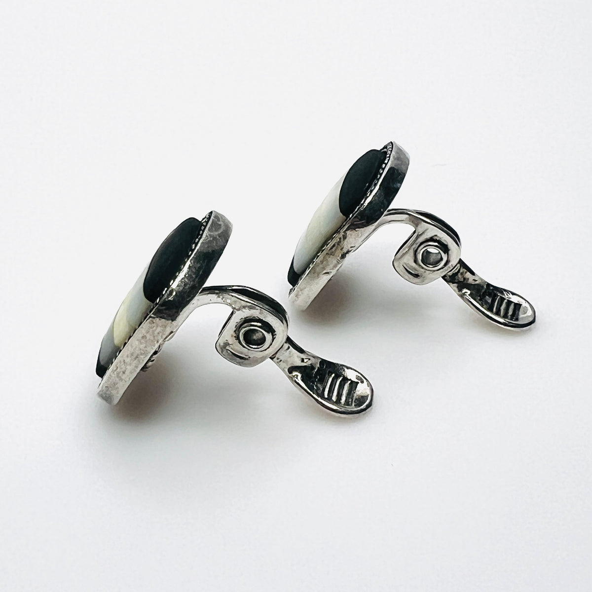 Side view of vintage Monet inlay clip-on earrings showing silver-tone clips