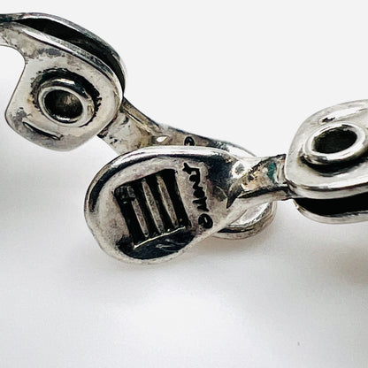 Close-up of MONET maker mark on vintage silver-tone clip earring fitting