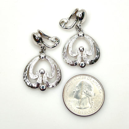 Mid-century Monet silver tone openwork dangle earrings with clip backs with quarter for scale