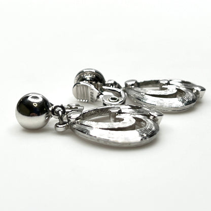 Side view of vintage Monet silver tone articulated clip-on earrings