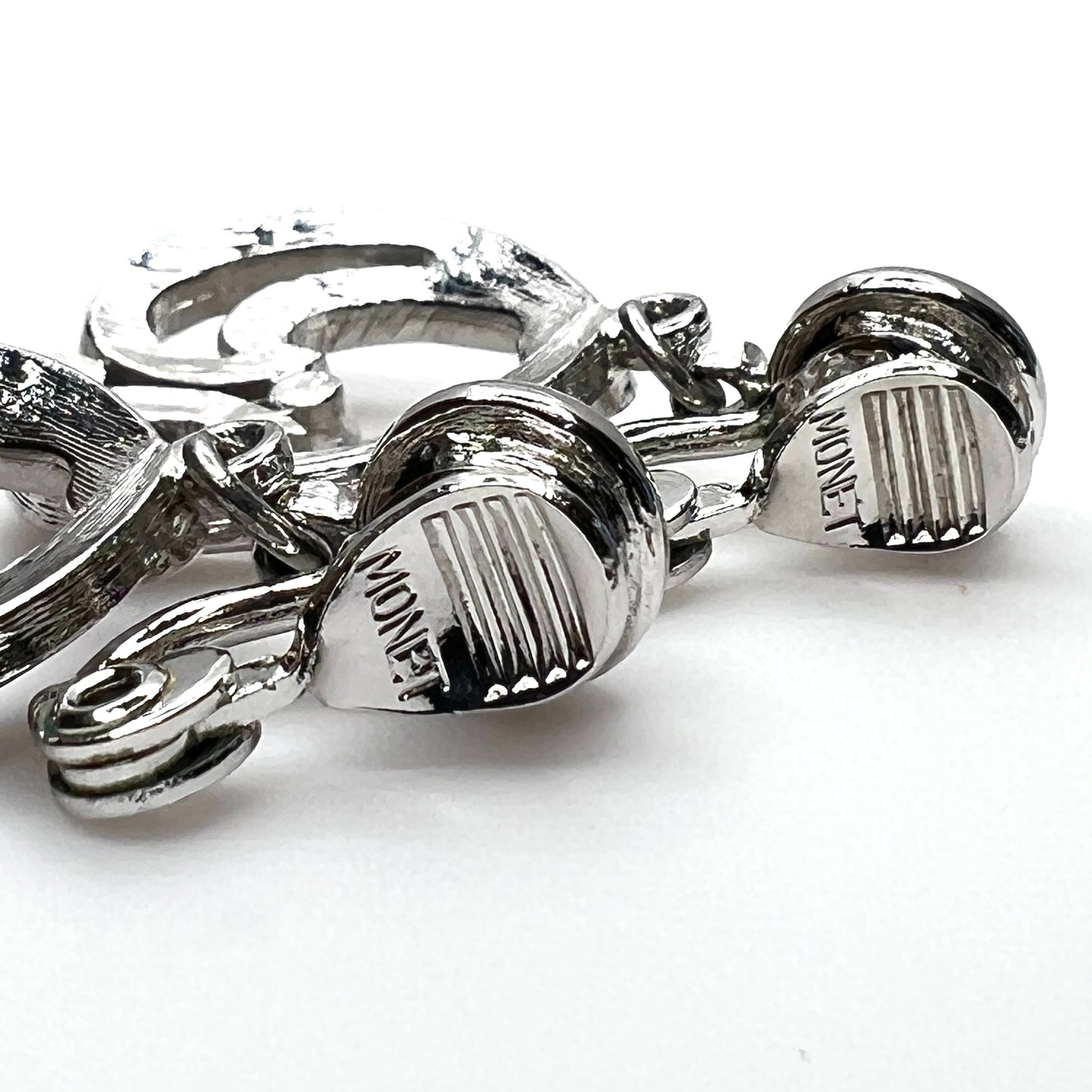 Close-up of Monet signature on vintage silver tone clip-on earrings