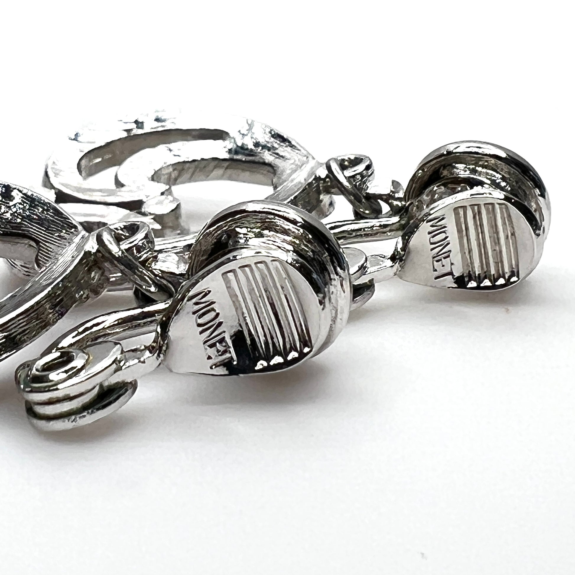 Close-up of Monet signature on vintage silver tone clip-on earrings
