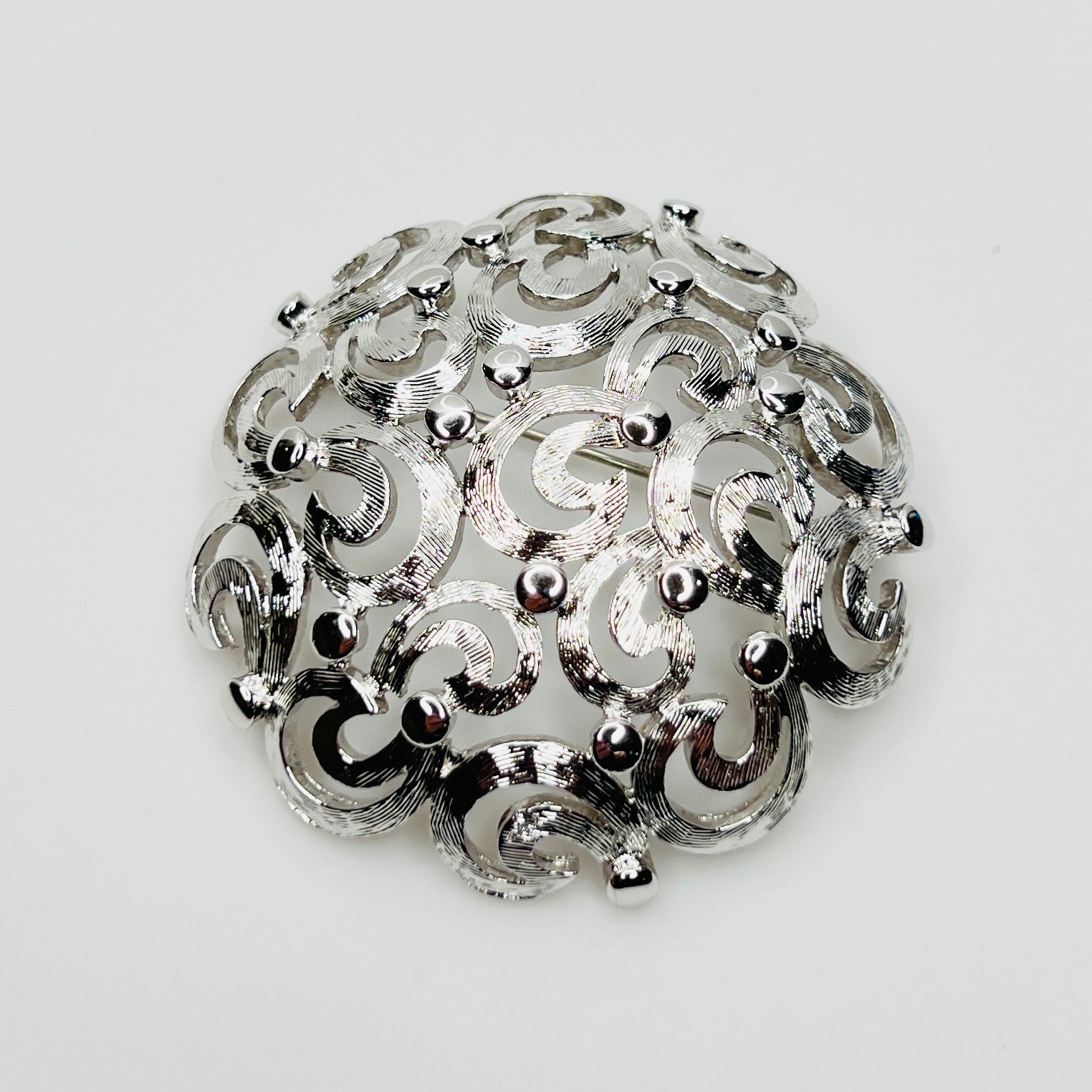 Vintage Monet silver tone swirl dome brooch filigree design
