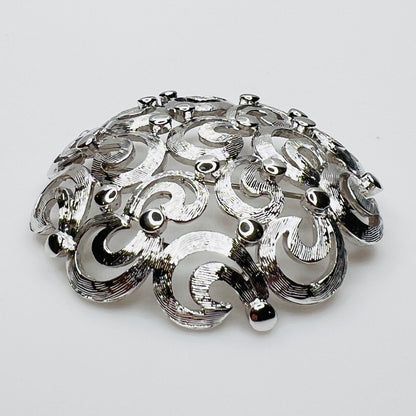 Side View of textured swirl filigree silver tone brooch