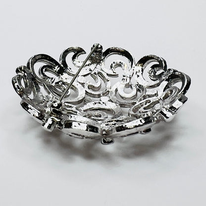 Close-up of textured swirl filigree silver tone brooch