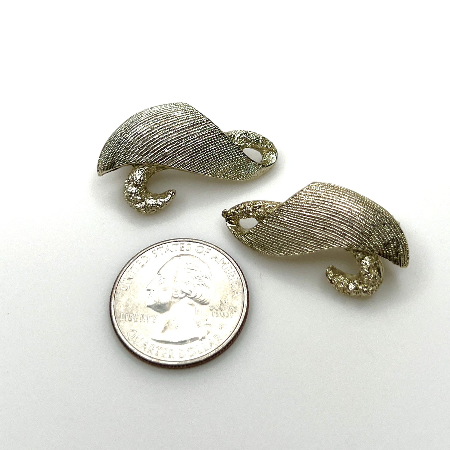 Mid-century Monet abstract swirl clip-on earrings in pale brushed gold tone with quarter for scale