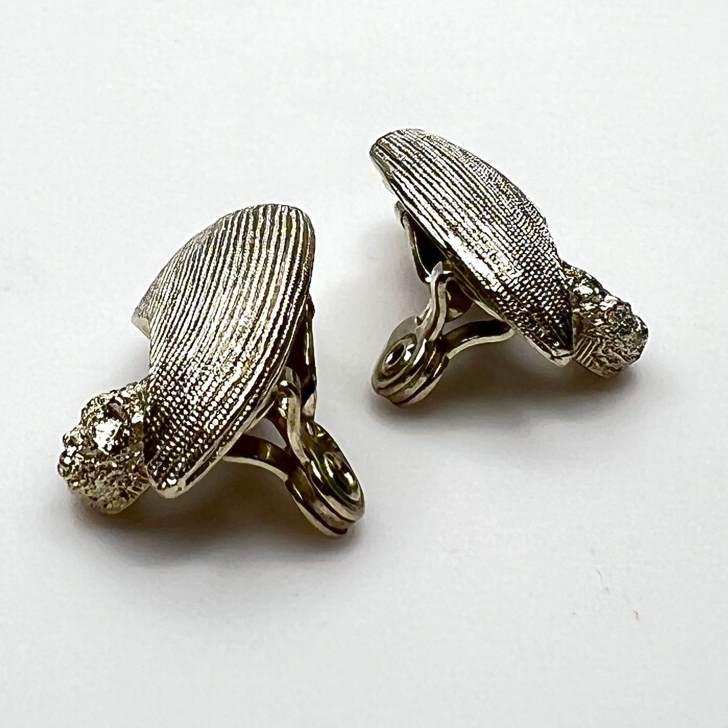Side view of vintage Monet sculptural brushed gold tone clip-on earrings