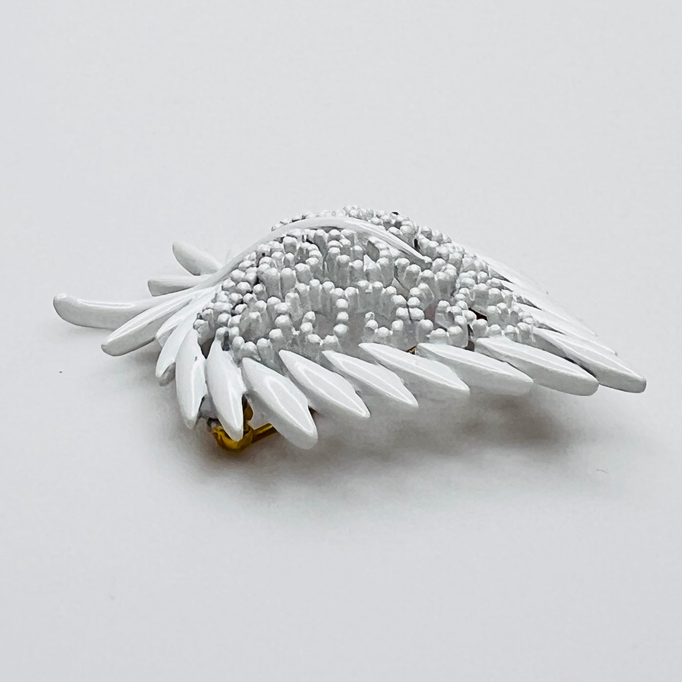 Side profile of vintage white enamel figural brooch