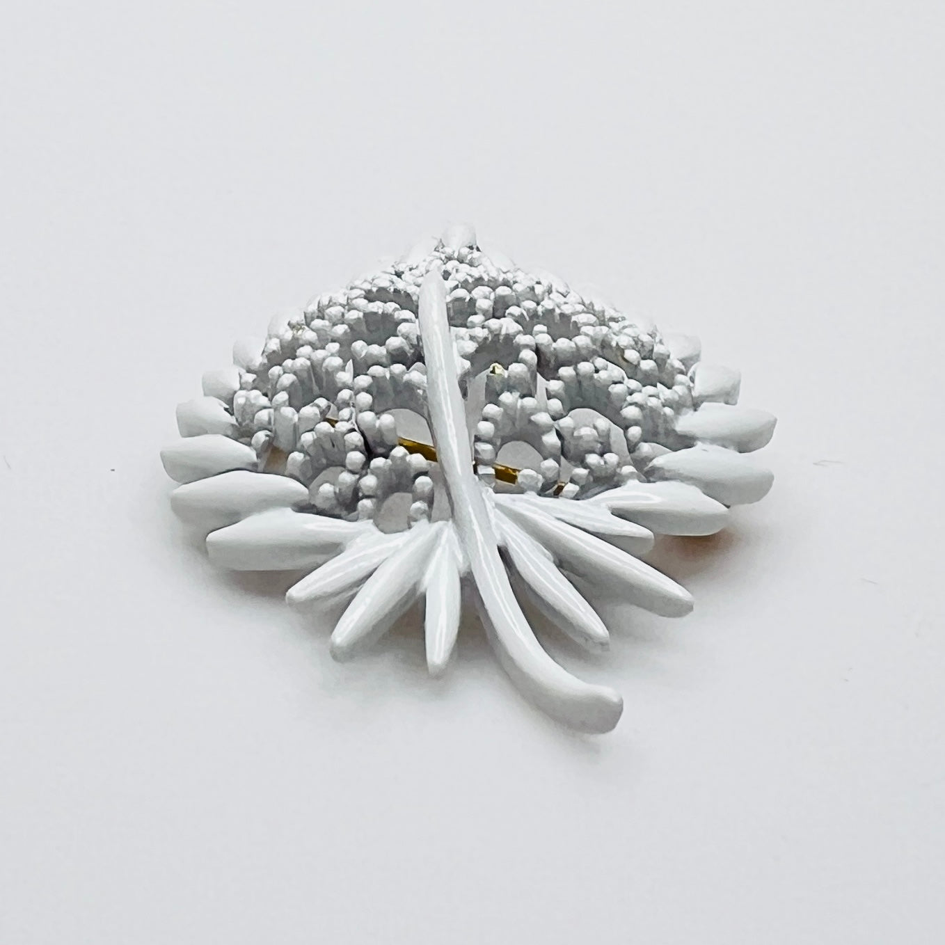 Side profile of vintage white enamel figural brooch