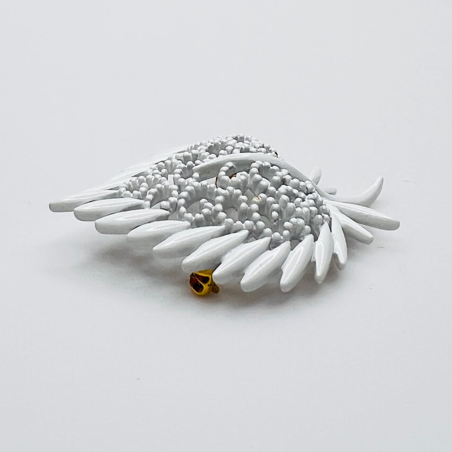 Side profile of vintage white enamel figural brooch