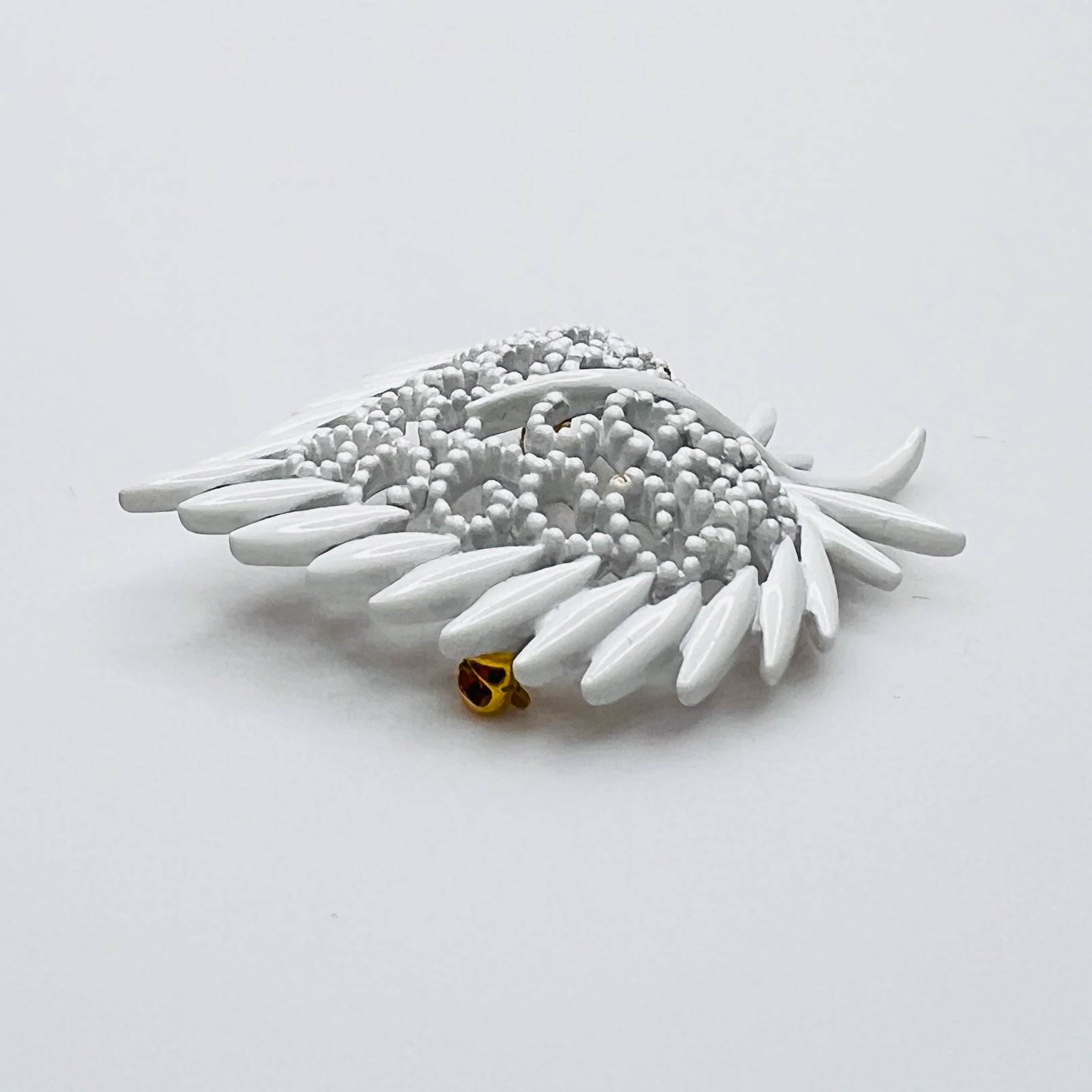 Side profile of vintage white enamel figural brooch