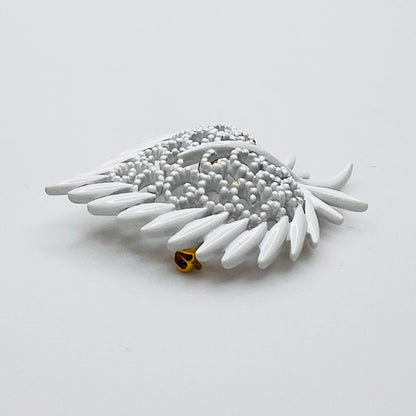 Side profile of vintage white enamel figural brooch