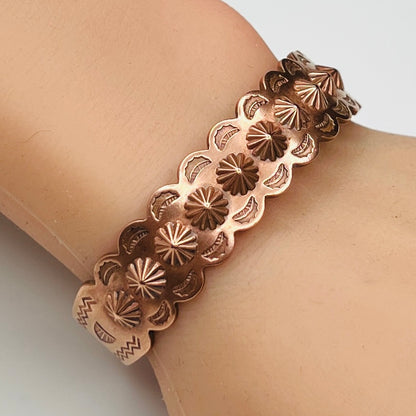 Solid copper cuff bracelet shown worn on wrist with sunburst details