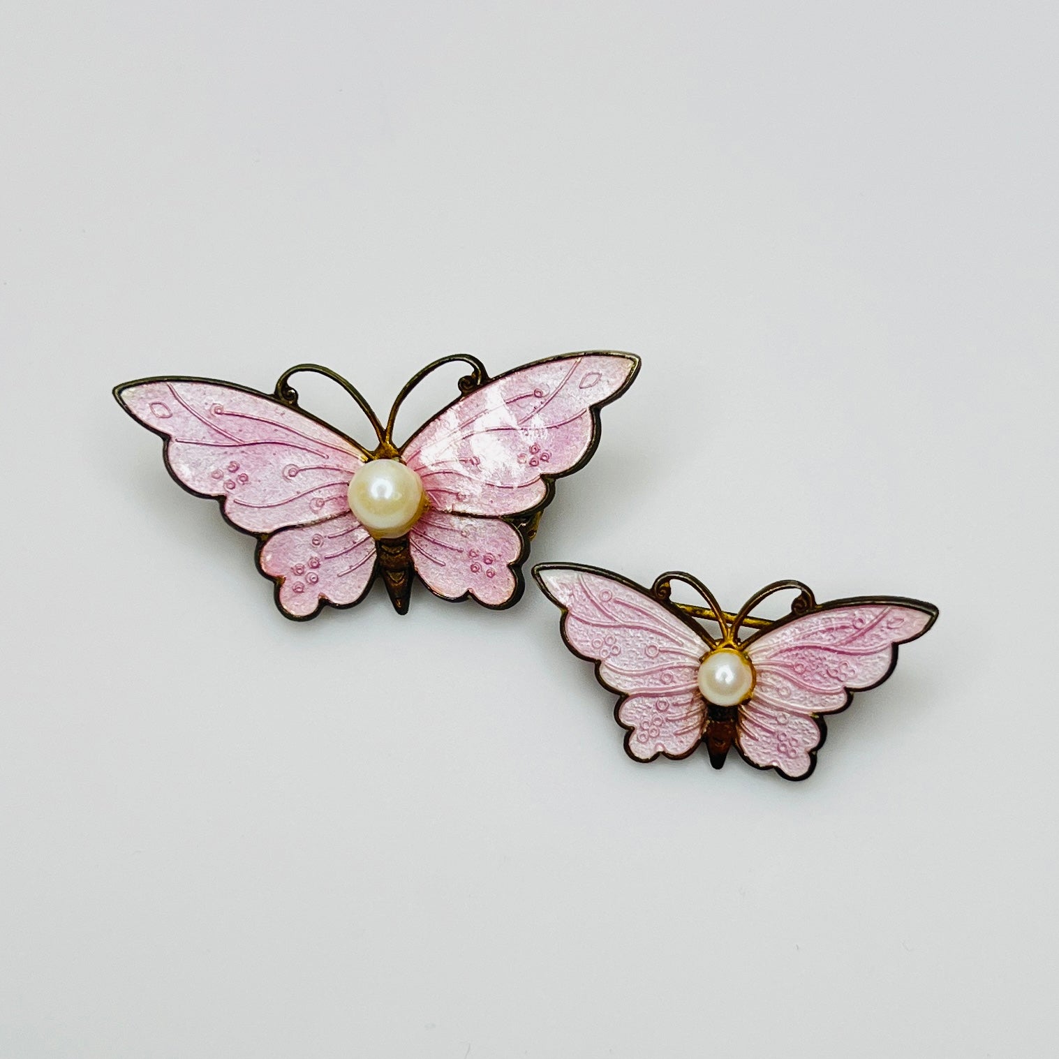 Pair of vintage pink enamel butterfly brooches with genuine pearl centers