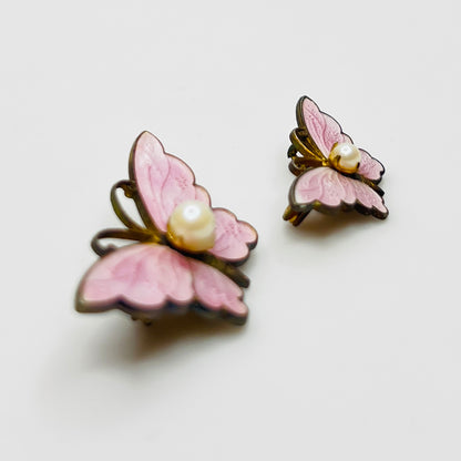 Side view of vintage butterfly brooches with pink enamel wings and pearls