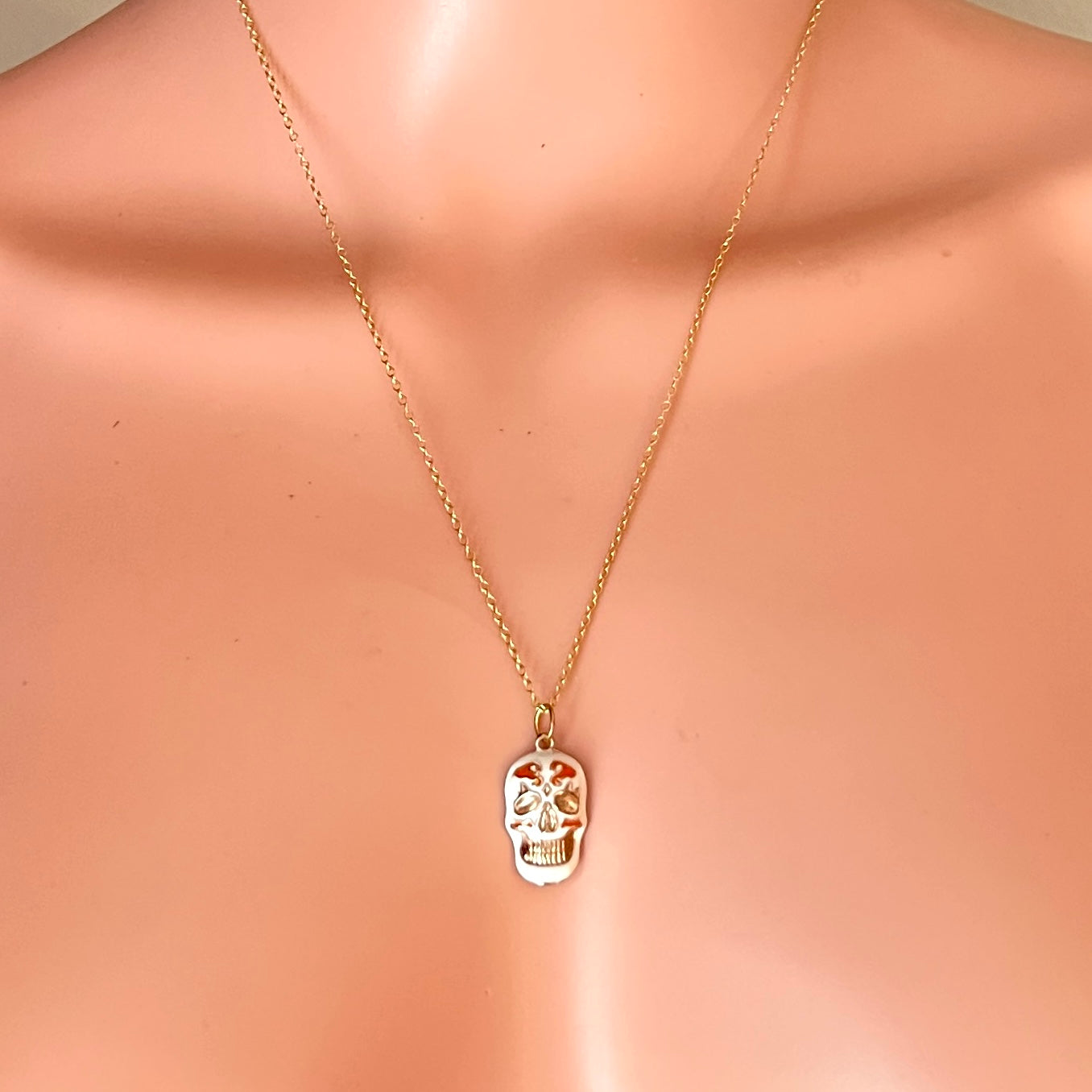 Vintage Day of the Dead skull pendant necklace displayed on mannequin.