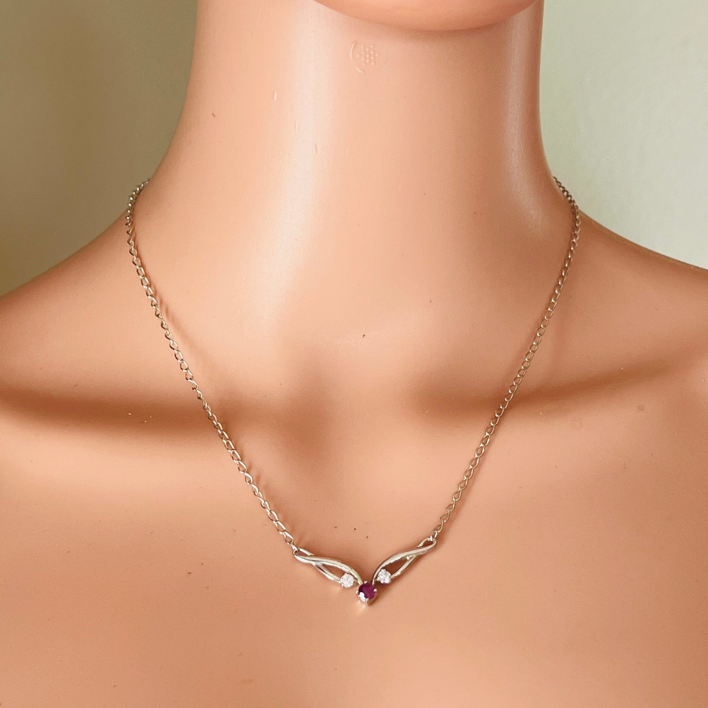 Vintage ruby necklace worn on mannequin with delicate chain