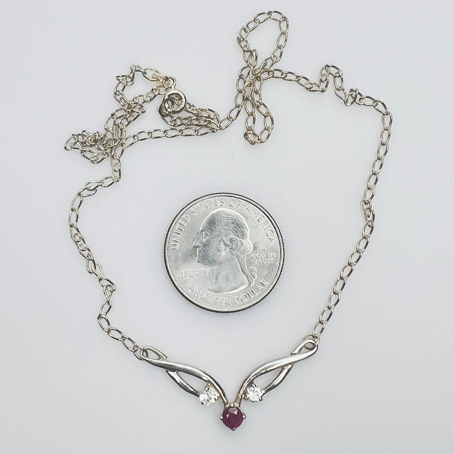 Close view of silver swirl pendant with ruby and CZ stones