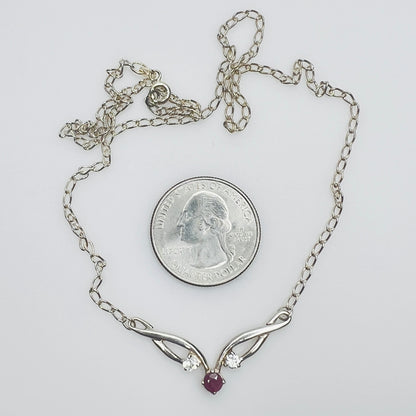 Close view of silver swirl pendant with ruby and CZ stones
