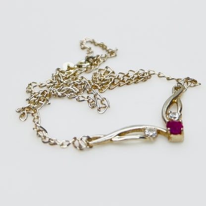 Close view of silver swirl pendant with ruby and CZ stones
