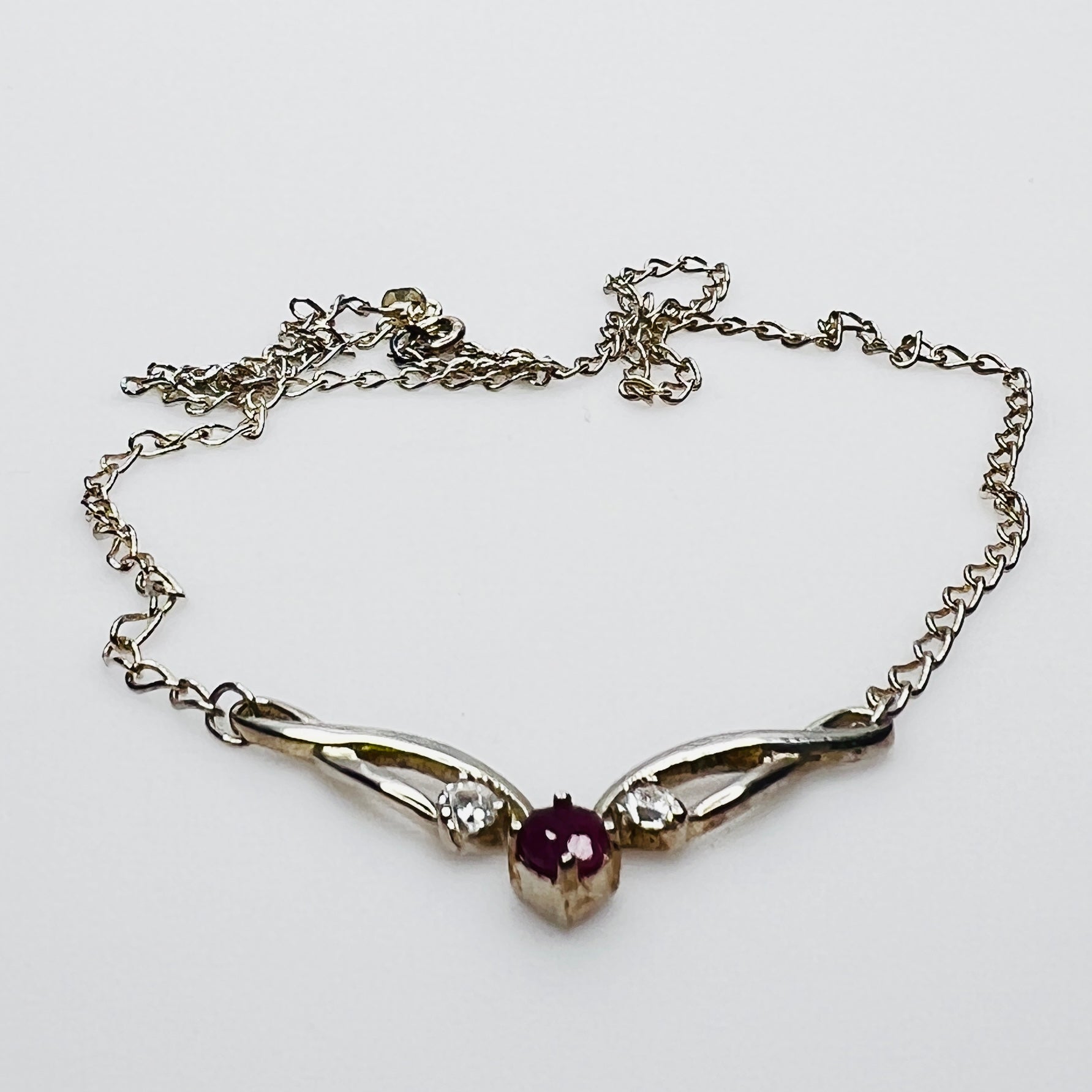 Close view of silver swirl pendant with ruby and CZ stones