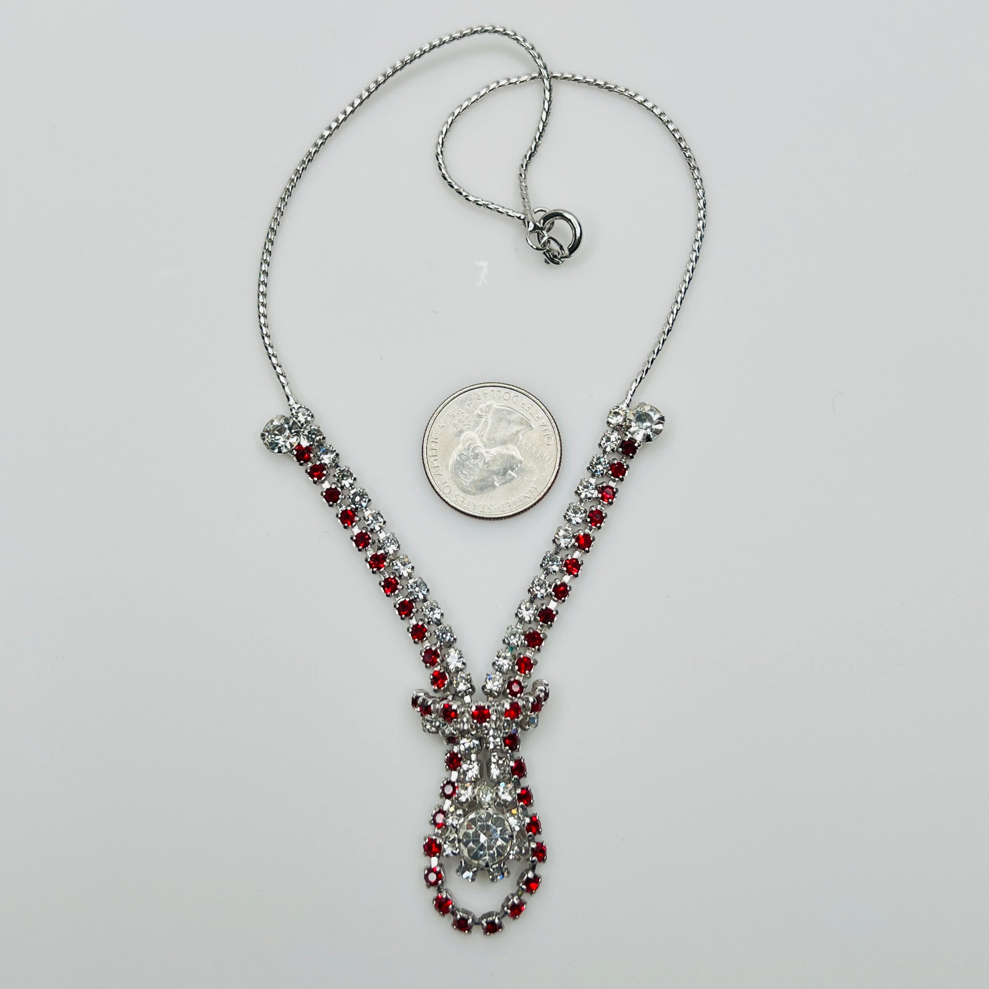 Vintage red and clear rhinestone necklace with quarter for scale, spring ring clasp