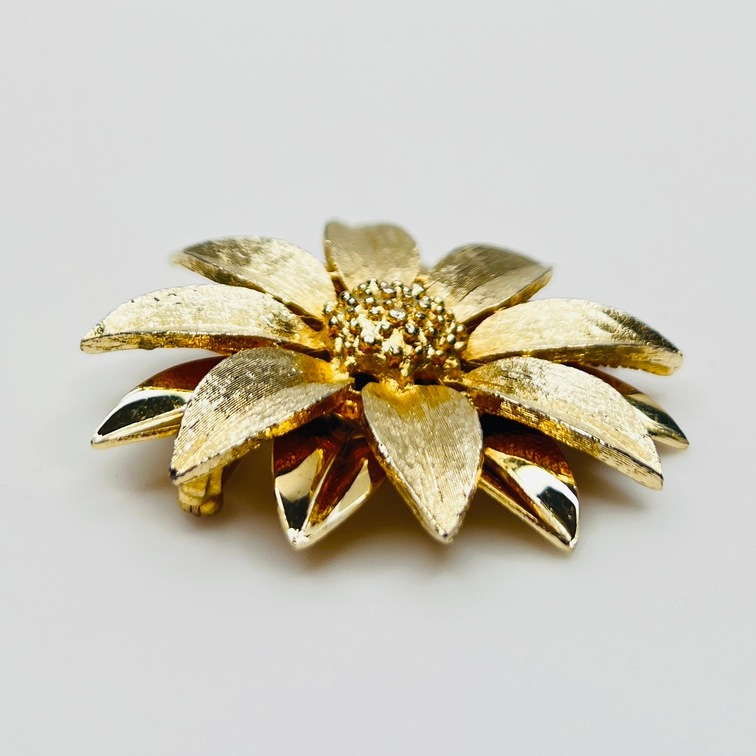 Side profile of layered daisy brooch