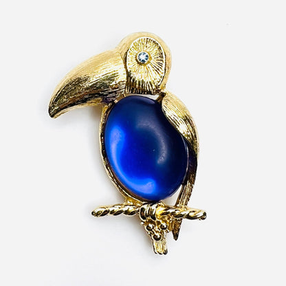 Vintage Sarah Coventry gold-tone toucan brooch with purple jelly belly and blue rhinestone eye