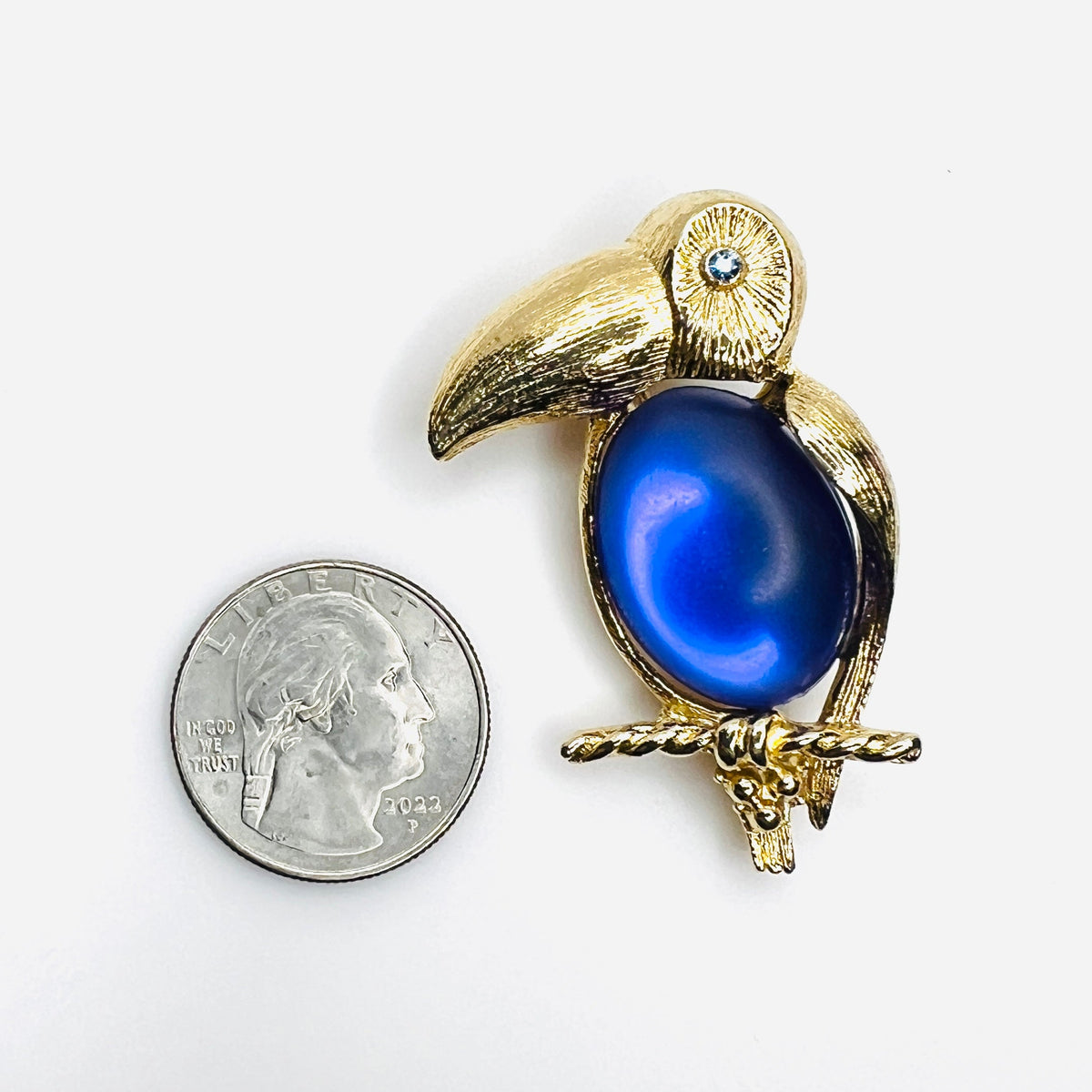 1970s Sarah Coventry purple jelly belly toucan brooch shown beside quarter for scale