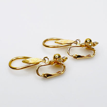 Side view Gold tone rhinestone dangle clip on earrings with open teardrop design